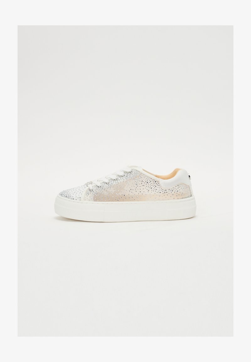 Shoe features a silver glittery upper with rhinestones, white rubber sole, lace-up design, and a beige interior lining. Side view.