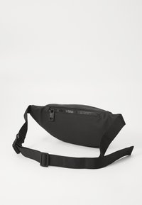 Marsupio nero realizzato in tessuto liscio, con chiusura a zip, cinturino regolabile e silhouette arrotondata. Design minimalista.