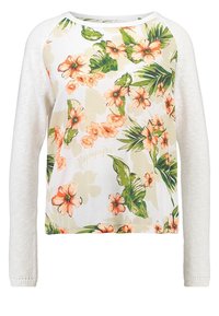 Weißes Langarmoberteil mit floralem Druck auf der Vorderseite, das Pfirsichblumen und grüne Blätter zeigt, sowie einfarbige weiße Strickärmel.