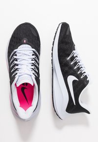 Sneaker sportive nere con accenti bianchi, tomaia in tessuto texturizzato, foderatura interna rosa a contrasto e suola in gomma con battistrada a motivo.