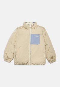 Beige polstret jakke med høy krage, elastiske mansjetter og en blå brystlomme med merkevaren sin logo. Blomstrete fôrinnredning inne.