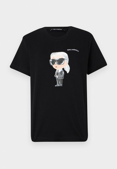 T-shirt en coton noir avec un graphique de personnage de dessin animé en gris et blanc, portant des lunettes de soleil et un costume, avec "KARL LAGERFELD" imprimé au-dessus.