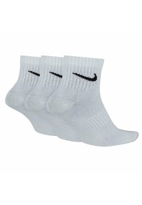 Tre par korta, vita strumpor med ribbat mönster och en svart swoosh-logga framtill. Tillverkade av lätt och andningsbart material.