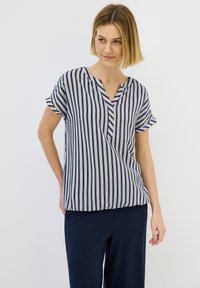 Blusa a maniche corte a righe blu navy e bianche, con scollatura a V e vestibilità ampia. Realizzata in tessuto leggero, presenta maniche arrotolate e un leggero orlo asimmetrico.