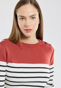 Rood en wit gestreepte trui met een geribbelde textuur, ronde halslijn en knoopdetails op één schouder.
