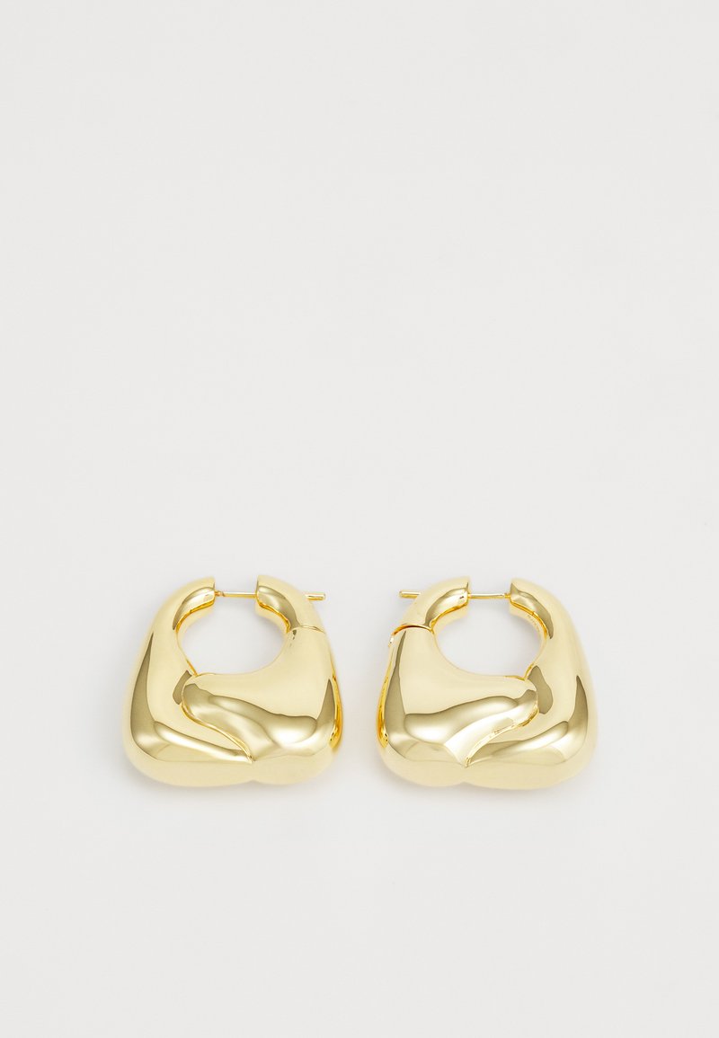 Arany tónusú fülbevalók, sima, szobrászati formával, kerek, szabálytalan alakban és fényes felülettel. Hipoallergén anyag.