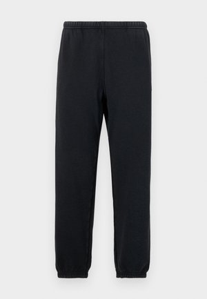 Black sweatpants with an elastic waistband and tapered ankles; made from soft, stretchy fabric, featuring a minimalist design without patterns.