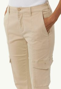 Beige cargobroek van een gladde katoenen stof, met zijzakken en een knoopsluiting. Inclusief dubbeldzijdig stiksel en een utility pocket.