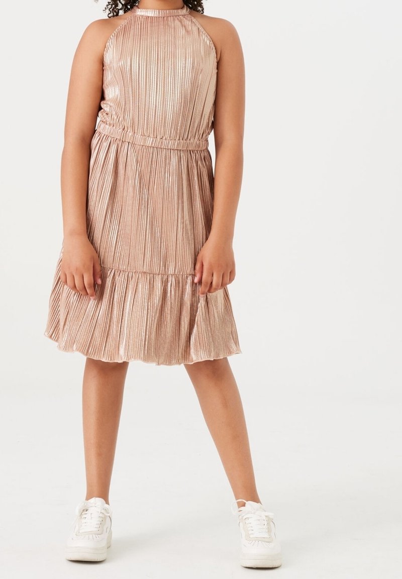Šifónové šaty v růžovo-zlaté barvě s plisovaným designem, halter krkem a elastickým pasem, s volánovým lemem. Vybavené bílými teniskami.