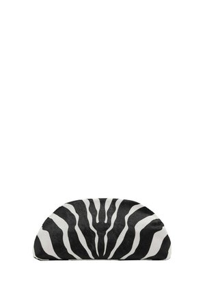 Un cojín semicircular con estampado de cebra en blanco y negro descansa sobre un fondo blanco liso.