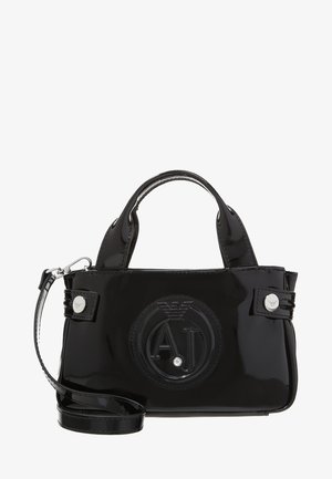 Sac à main noir brillant avec anses supérieures, bandoulière amovible et logo circulaire embossé avec les lettres A et J sur le devant.