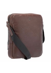 Bruine leren crossbodytas met een gladde textuur; voorzien van een zwarte verstelbare riem en een subtiel logo aan de voorkant. Vierkante vorm.