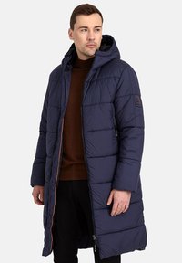 Parka lunga da uomo in blu navy, design trapuntato, cappuccio, chiusura con zip frontale, fodera interna arancione, tasche laterali, polsini aderenti e patch del marchio sulla manica.