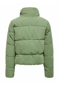 Chaqueta acolchada de pana verde con cuello alto, diseño acolchado y tela texturizada. Presenta secciones acolchadas y mangas largas.