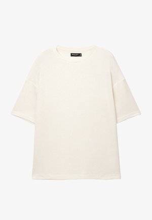 Fehér, bordázott kötött póló kerek nyakkivágással és rövid ujjakkal. Puha tapintású, laza szabású, látható logók vagy minták nélkül.