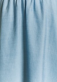 Světle modrá bavlněná tkanina s hladkou texturou, s nařasenými detaily v pase pro vzdušný, splývavý vzhled.