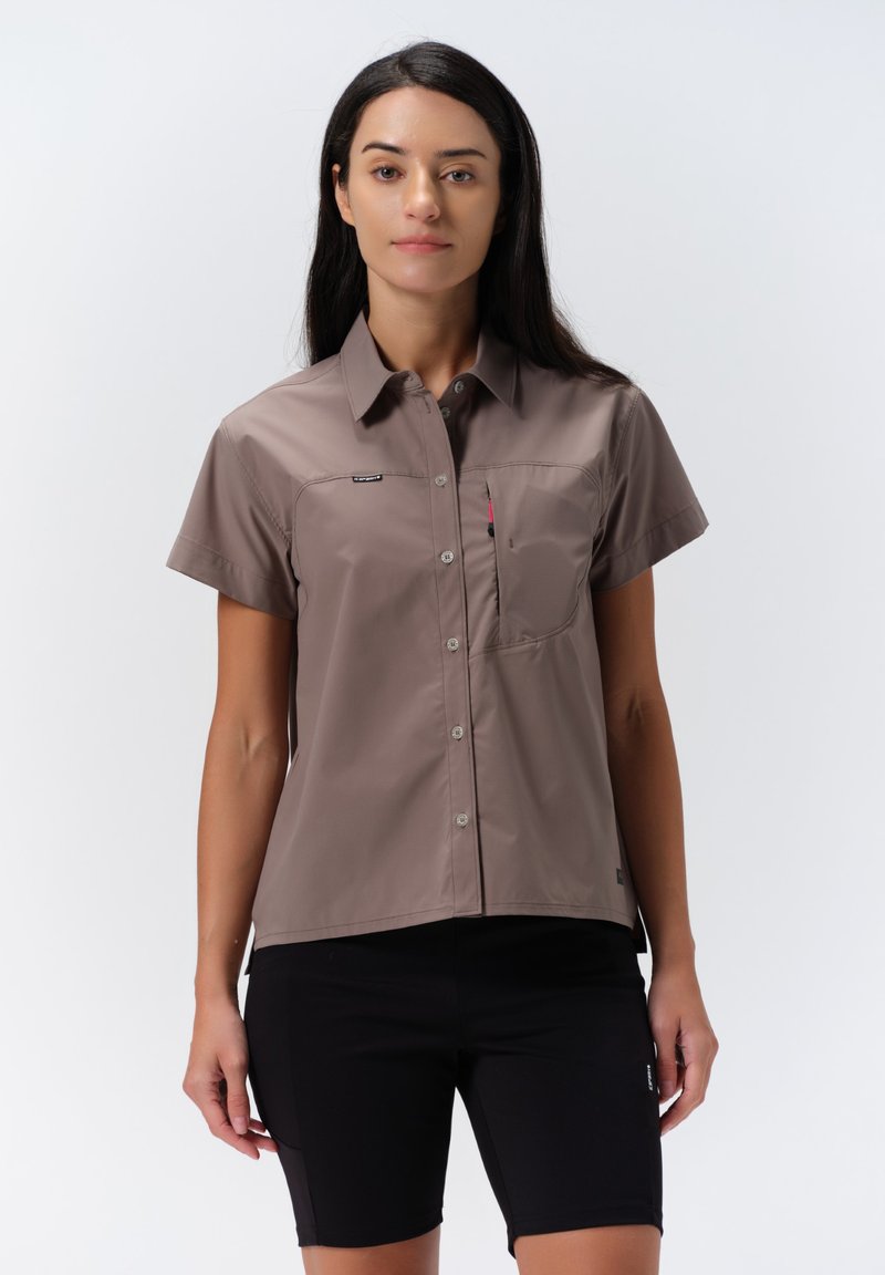 Korte mouwen, overdracht blouse in lichtbruin stof, met een borstzak en subtiele merkdetail op de linkerkant van de borst.
