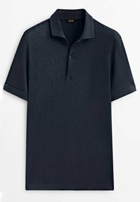 Polo bleu marine en tissu lisse, doté d'un col à deux boutons et de manches courtes avec revers roulés.