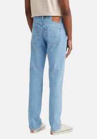 Jeans in denim azzurro chiaro con design a gamba dritta, dotati di tasche posteriori, cuciture visibili e un'etichetta del marchio sulla vita.