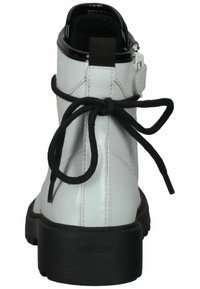 Botas de tobillo blancas con un acabado brillante, cordones negros, cierre con cremallera en la parte trasera y una suela negra acolchada con detalles de logotipo en relieve.