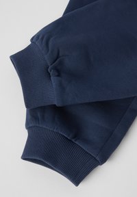 Marineblå sweatshirtærmer med ribbet tekstur og elastiske åbninger, der har en let løs pasform og en glat stoffinish.