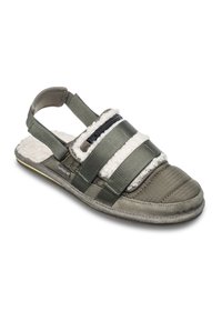 Sandal fermé avec des brides en tissu vert olive, doublure en polaire blanche, détail de fermeture éclair et sangle de talon ajustable sur un fond clair.