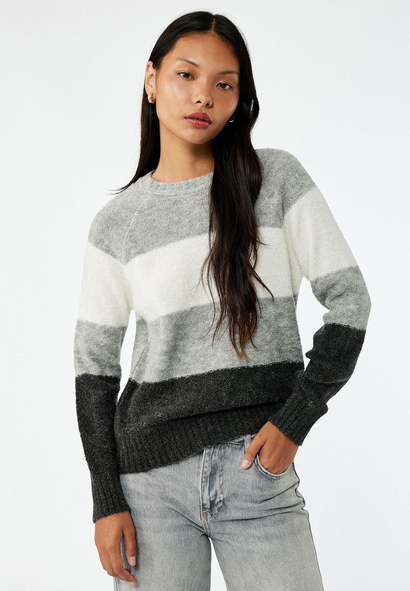 Suéter de punto con rayas horizontales en tonos de gris y blanco. Presenta puños y dobladillo acanalados, textura suave y cuello redondo.