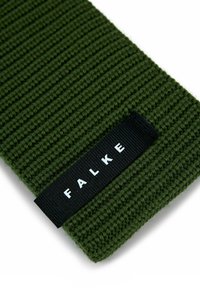Sezione di tessuto a maglia a coste verde scuro con un'etichetta intrecciata nera che presenta il testo bianco "FALKE".