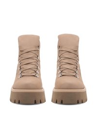 Béžové členkové topánky s hladkým semišovým povrchom, okrúhlym špičkou, hrubou platformou a kovovými šnúrkami.