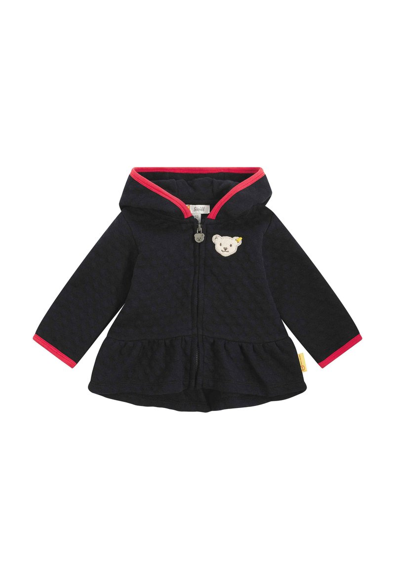 Giacca a vento blu navy con bordi rosa, tessuto texturizzato, chiusura con zip e una patch a forma di orso sul petto; orlo svasato e maniche lunghe.