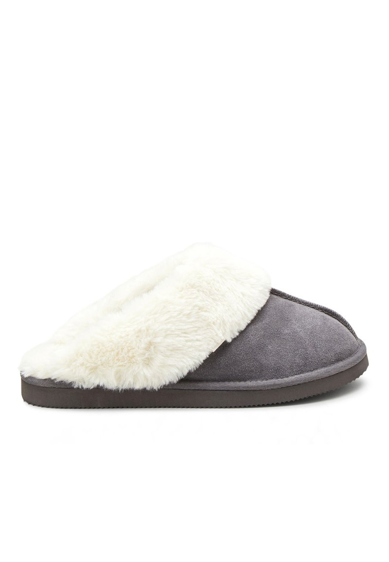 Chausson en suède gris avec un col en fausse fourrure blanche, forme arrondie, semelle plate et texture lisse. Comprend une couture et aucun élément métallique visible.