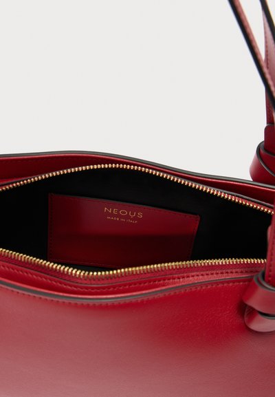 Sac à main en cuir rouge avec fermeture éclair dorée partiellement ouverte, dévoilant l'intérieur noir et une poche rouge étiquetée "NEOUS Made in Italy".