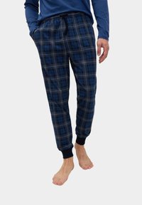 Mænds navy rute-mønstret pyjamasbukser med elastisk talje, sidelommer, ribbede manchetter og en blød stofstruktur. Kommer godt sammen med en langærmet top.