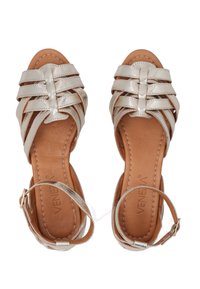Beige metallic sandalen met kruisbanden en enkelgesp. Gladde leren binnenzool met gestikte details. Open teen ontwerp.