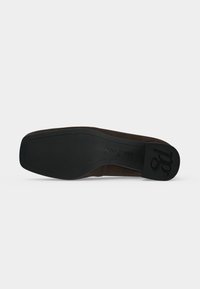 Semelle d'une chaussure marron foncé à bout carré, semelle en caoutchouc noire et marquage en relief « paul green » près de la voûte plantaire et du talon.
