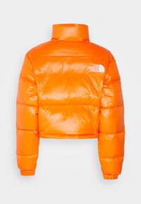 Krótkia kurtka puchowa w jaskrawym pomarańczowym kolorze, wykonana z błyszczącego materiału. Posiada wysoki kołnierz oraz elastyczne mankiety, z białym logo na lewym ramieniu.