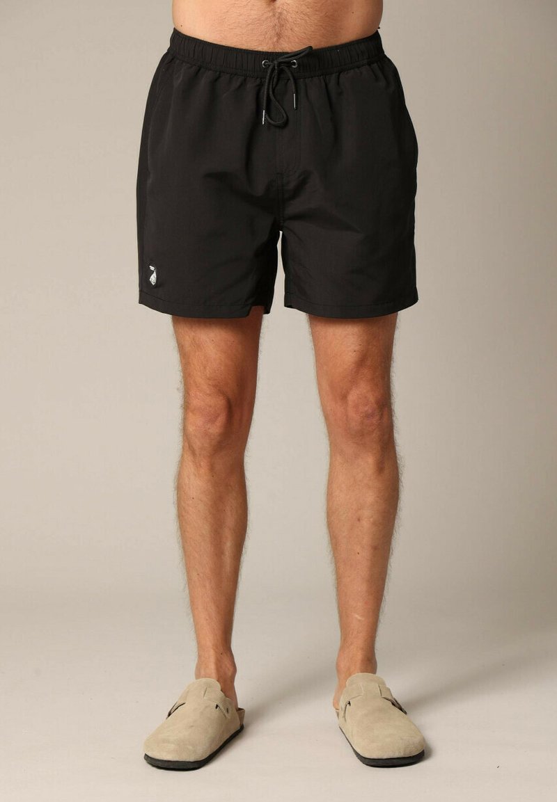 Shorts de bain noirs avec une taille élastique et un cordon de serrage réglable. Présente un petit logo blanc sur le côté gauche. Tissu doux et léger.