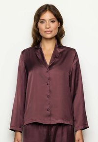 Camisa de pijama de satén burdeos con mangas largas, cuello y cierre de botones en la parte delantera. Textura suave, corte relajado y dobladillo recto.