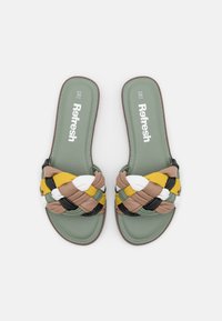 Chanclas verdes con tiras trenzadas en colores marrón, amarillo, negro y blanco. Textura suave con una plantilla acolchada.