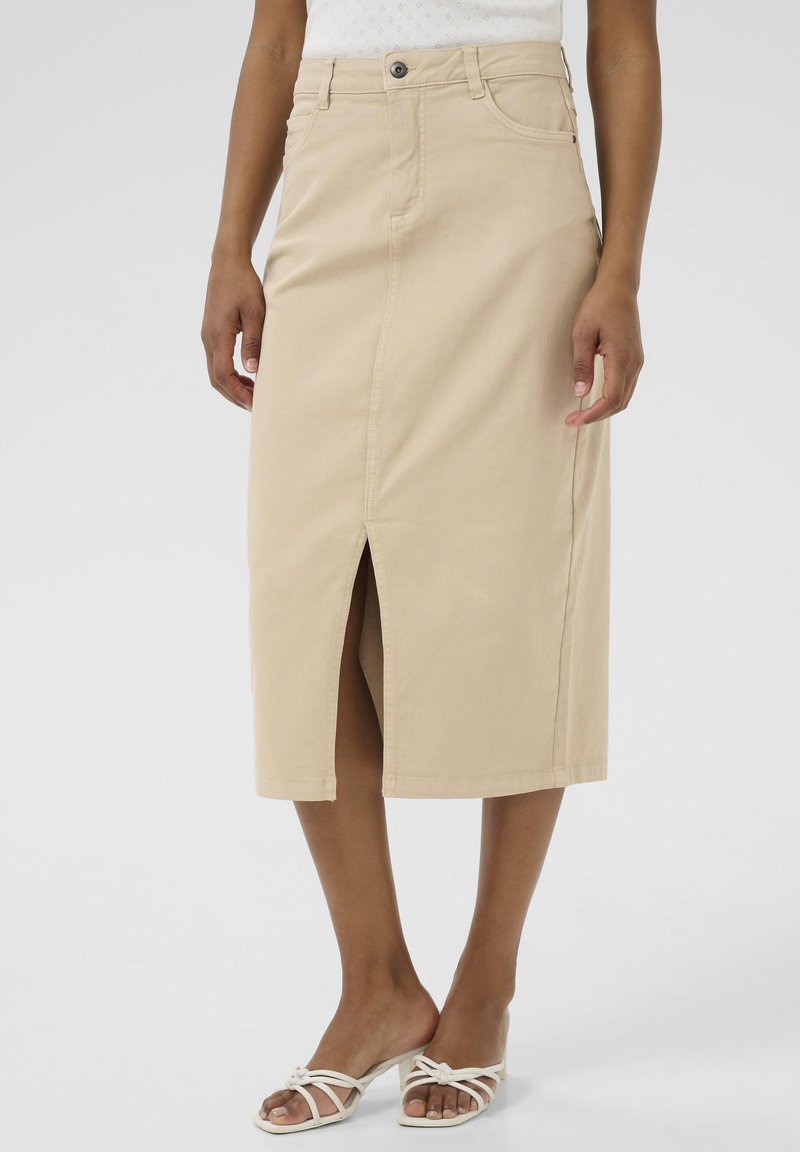 Knee-length beige džinsinė sijonas su priekine skeltimi, mygtukų uždarymu ir penkių kišenių dizainu. Lygus paviršius ir prigludusi siluetė.
