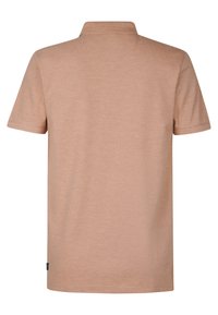 Polo tričko s krátkým rukávem v světle béžové barvě, vyrobené z měkké tkaniny. Má klasický límec a rovný spodní lem s minimálním šitím.