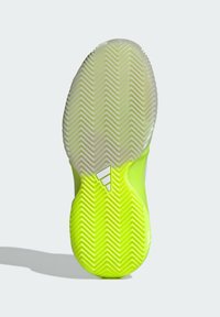 Suela de zapato con un diseño amarillo brillante y translúcido, con un patrón de espiga para tracción, incluyendo detalles del logo en blanco.