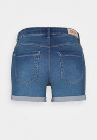 Denimshorts med en medelhög midja, upprullade fållar och två bakfickor. Färgen är en mellanblå med en slät yta.