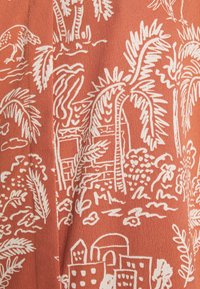 Tkanina terakotowa z białym, ręcznie rysowanym wzorem palm, budynków i elementów przyrody, o miękkiej teksturze i lekkim wyglądzie.