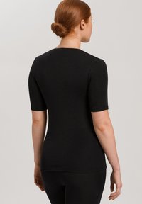 Svart kortärmad topp med en figursydd design, slät textur och rundad halsringning, som har en sömlös baksida utan synliga sömmar.