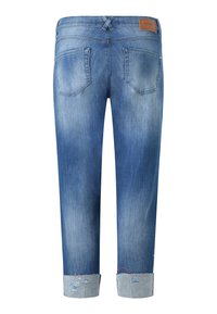 Jeans de mezclilla azul con un acabado ligeramente desgastado. Presenta puños enrollados, bolsillos traseros y una etiqueta de cuero de la marca en la cintura.