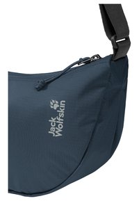 Sac bandoulière bleu marine Jack Wolfskin avec fermeture éclair et sangle noire réglable, présenté en gros plan.