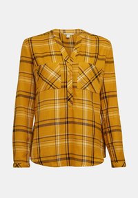 Chemise à manches longues, à carreaux jaune moutarde, avec deux poches avant, col en V et boutons apparents. Le tissu semble doux avec une légère texture.