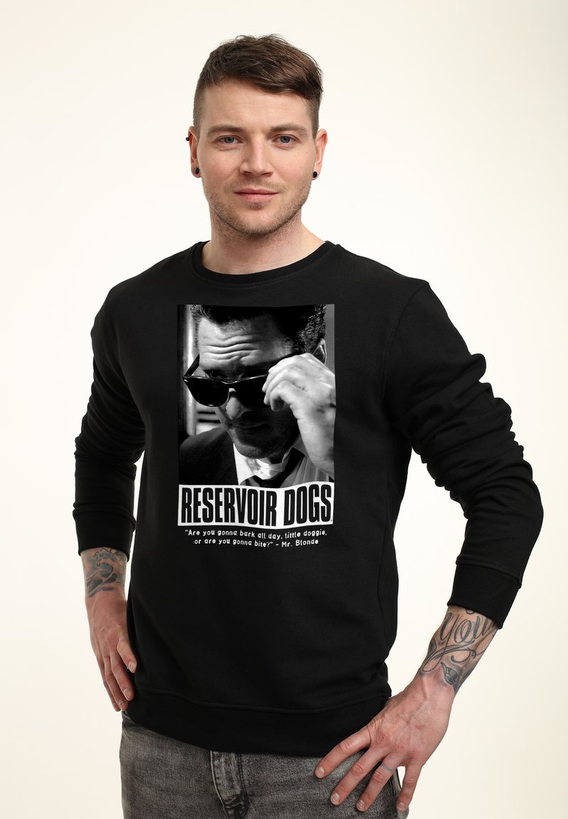Felpa nera con una grafica stampata di un personaggio con occhiali da sole tratto da "Reservoir Dogs". Sotto c'è la scritta "RESERVOIR DOGS."