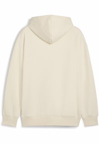 Grietinėlės spalvos džemperis su lygiu paviršiumi, turintis didelę kepurę ir plačias rankoves. Raukšlės ant rankovių ir liemens krašto užtikrina tvirtą prigludimą.